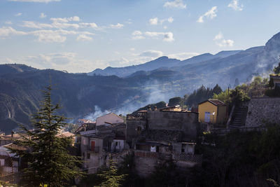 Houses and buildings in town against sky