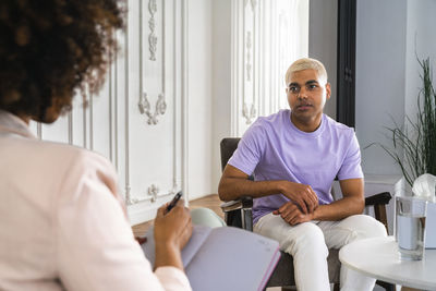 Psychologist with patient sitting in armchair at workplace