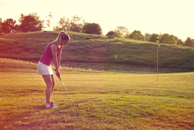 Full length of woman standing on golf course