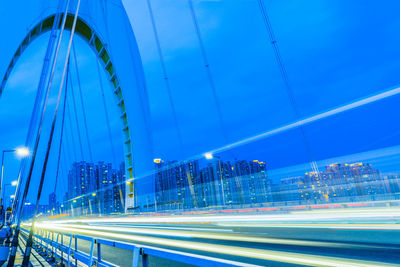 Light trails on road against buildings at night