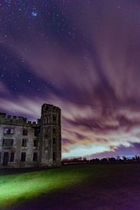 Built structure on field against sky at night