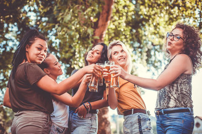 Happy women doing celebratory toast on land