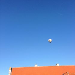 Paragliding against clear blue sky