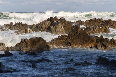 Scenic view of rocks in sea against sky