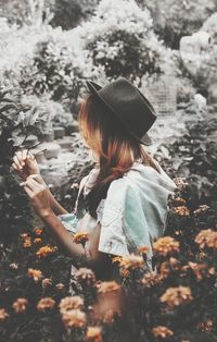 Side view of girl holding plant