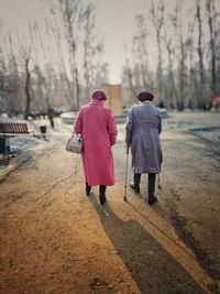 Rear view of people walking on footpath