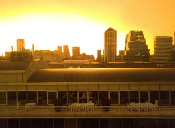 View of city buildings against clear sky during sunset