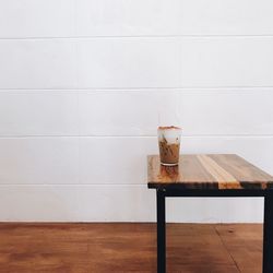 Table and chairs on wooden floor against wall