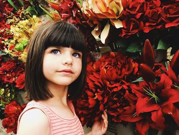 Close-up of girl by artificial flowers in shop