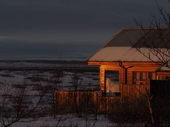 House by sea against sky during winter