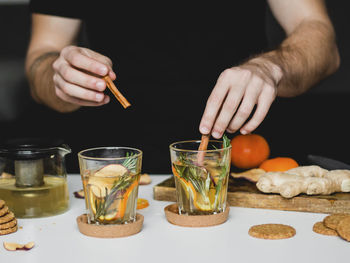 Cropped image of hand holding drink on table