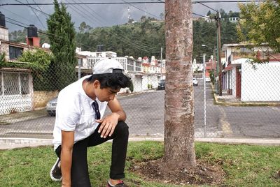 Full length of young man sitting outdoors