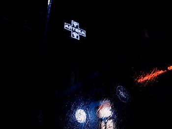Illuminated text on wet wall at night