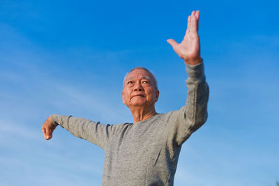 Low angle view of woman against blue sky