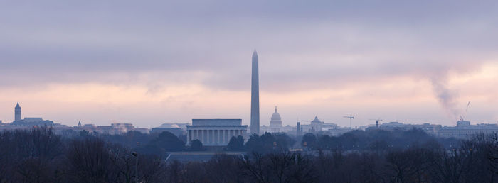 Panoramic view of buildings against cloudy sky