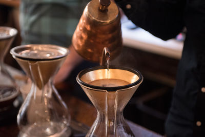 Midsection of man making coffee on table