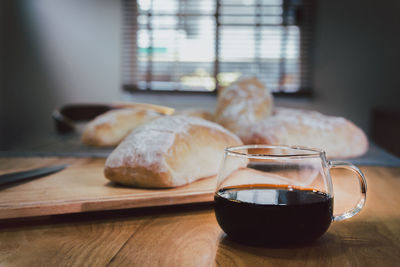 Black coffee with homemade italian bread on wooden table in the morning.