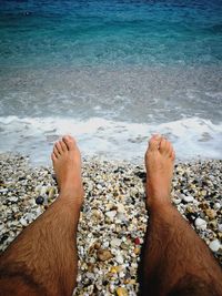 Low section of man relaxing on beach