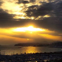 Scenic view of sea against dramatic sky during sunset