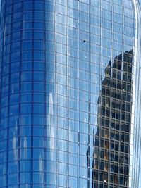 Low angle view of modern building against blue sky