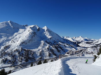 Scenic view of snowcapped mountains against clear blue sky