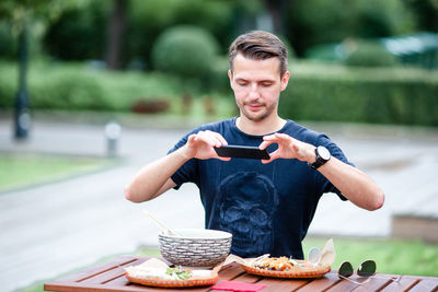 Full length of man holding ice cream on table