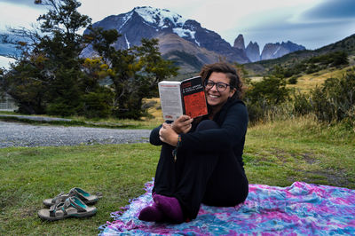 Portrait of smiling young woman sitting on field