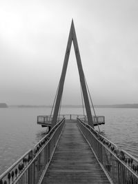 Jetty in lake against sky