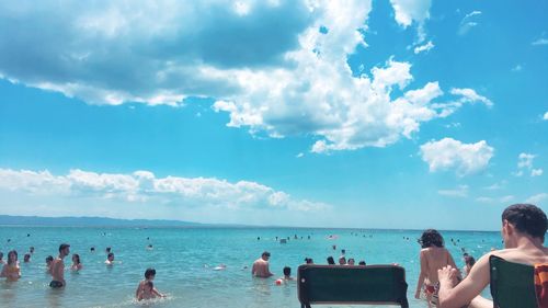 People on beach against sky