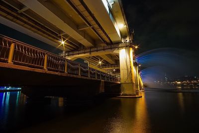 Low angle view of bridge over river at night