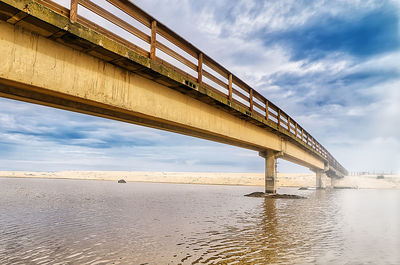 Low angle view of bridge over sea against sky