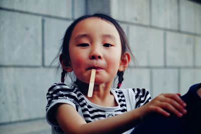 Portrait of cute girl with ice cream stick in mouth