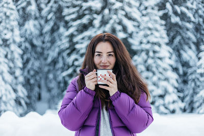 Portrait of young woman wearing warm clothing standing outdoors