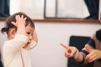 Mother pointing at daughter