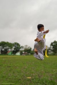 Full length of boy practicing martial arts at park