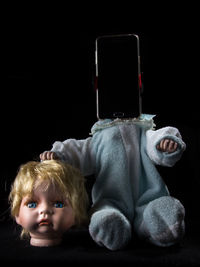 Close-up of doll and smart phone against black background