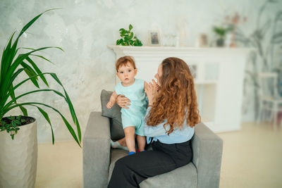 Mother with baby on a gray chair. high quality photo