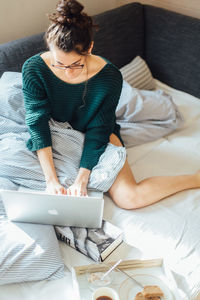 High angle view of woman sitting on sofa at home