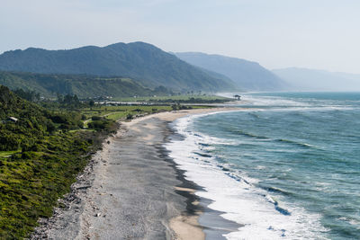 Scenic view of sea and mountains against sky