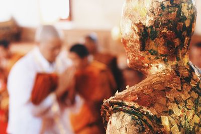 Rear view of people holding sculpture