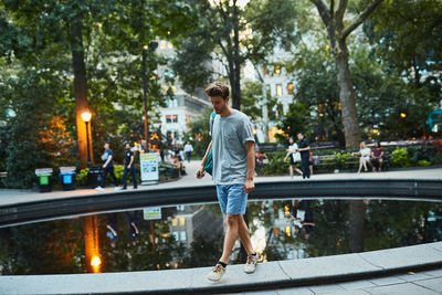 Man with arms raised in park