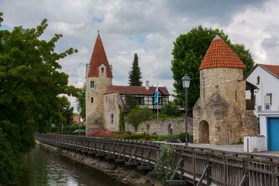 Bridge over river amidst buildings against sky