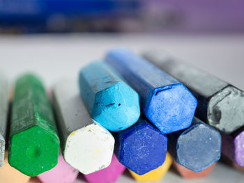 Close-up of multi colored pastel crayons on table