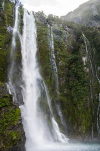 Scenic view of waterfall against sky