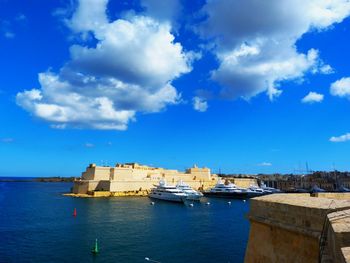 Boats in sea against buildings in city