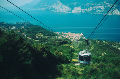 Overhead cable car over mountains against sky