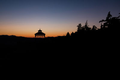 Silhouette building against sky during sunset