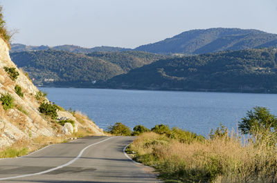 Scenic view of lake by mountains against clear sky