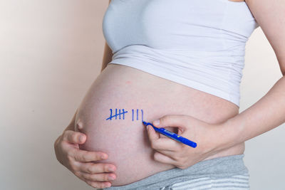 Midsection of woman standing against wall