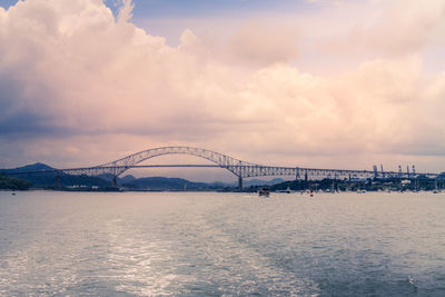 View of bridge over sea against cloudy sky